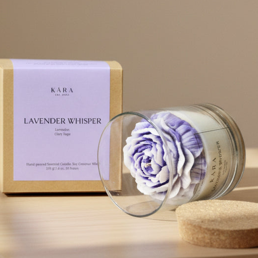 Kara Lavender Whisper candle with a purple rose and packaging on a neutral background