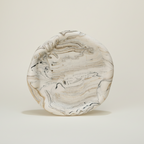 Marble-patterned ceramic plate on a beige background