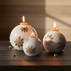Three decorative candles shaped like Christmas balls with snowflake patterns on a wooden surface.