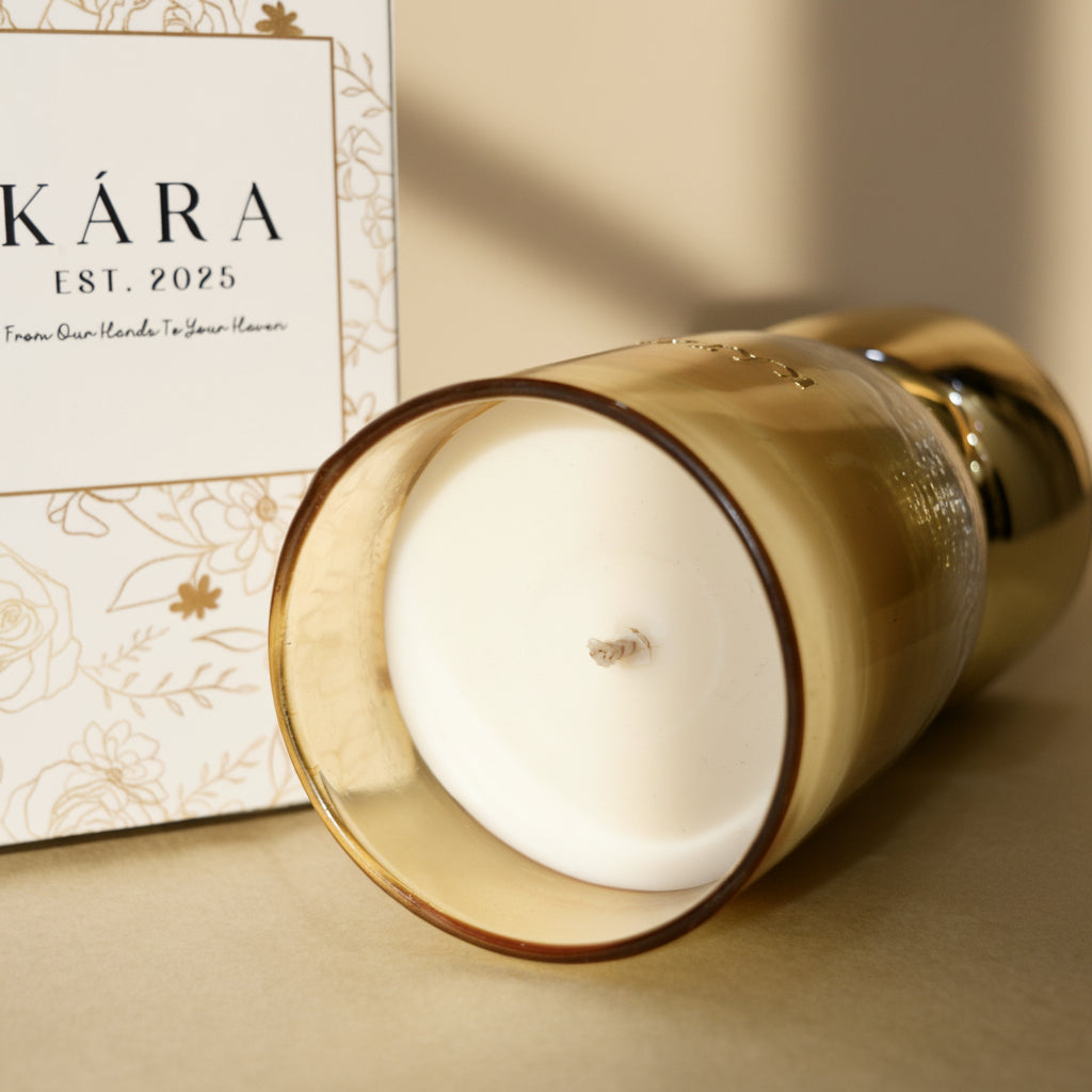 Gold candle holder with a white candle inside, KÁRA brand visible in the background.