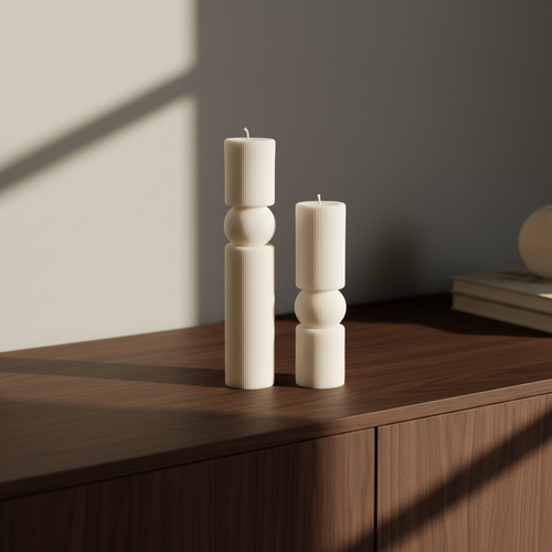Two white candles on a wooden surface with a minimal background